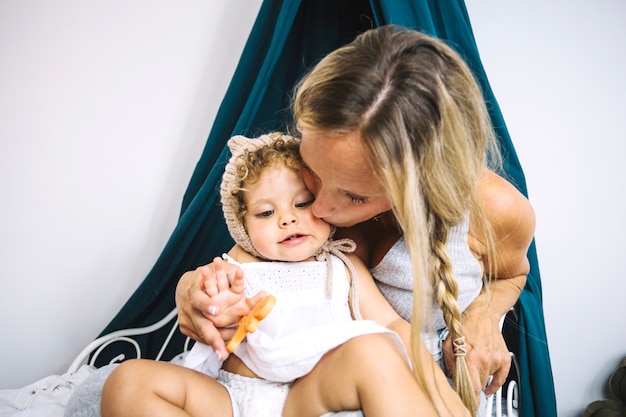 Foto gratuita madre besando a hija en la mejilla