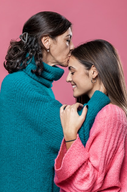 Madre besando a niña en la frente