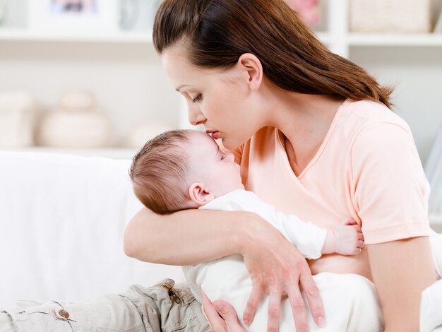 Madre besando a su bebé dormido