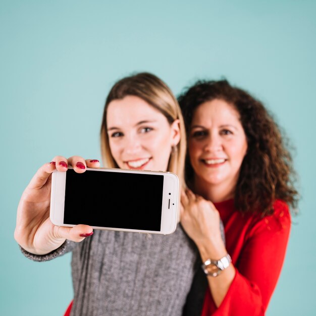 Madre borrosa e hija posando para selfie