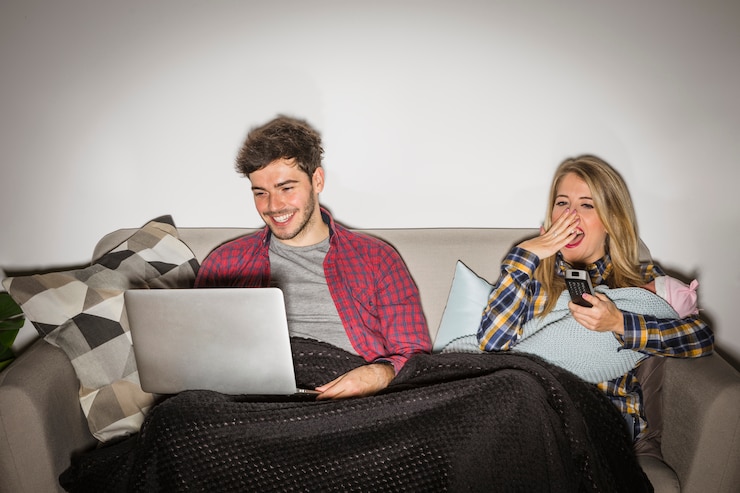 Foto gratuito madre cansada con el bebé que ve la tv mientras que padre que usa el ordenador portátil