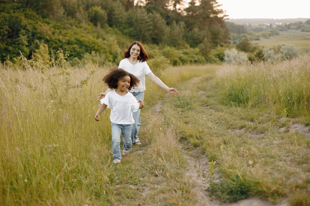 Madre caucásica y su hija afroamericana corriendo juntos