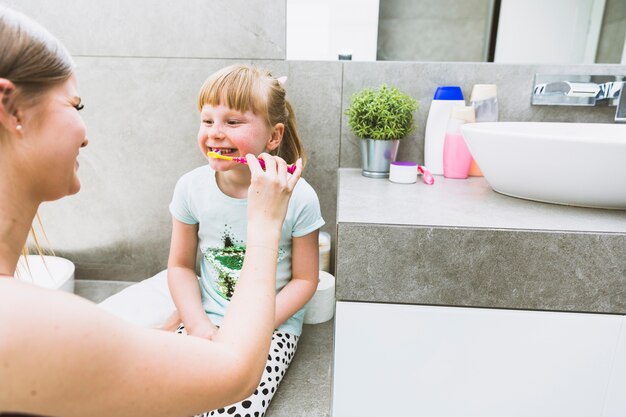 Madre cepillarse los dientes de la hija