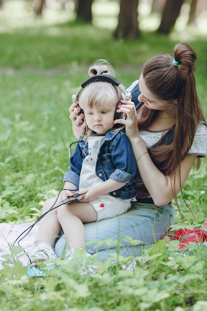 Madre colocando auriculares a su hija pequeña