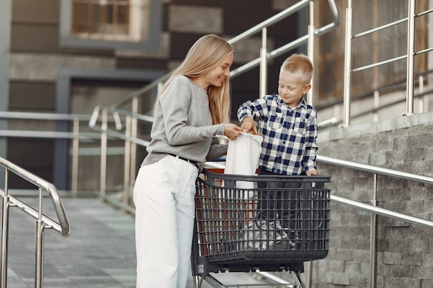 La madre conduce un tranvía. Familia en un parking cerca de un supermercado.