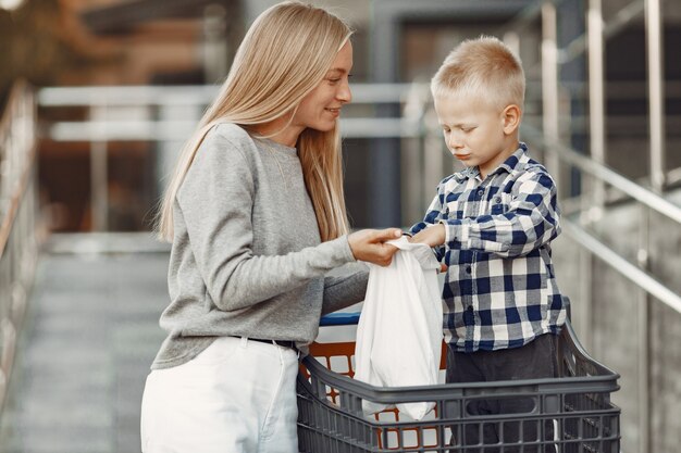 La madre conduce un tranvía. Familia en un parking cerca de un supermercado.