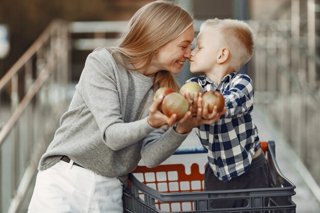 La madre conduce un tranvía. Familia en un parking cerca de un supermercado.