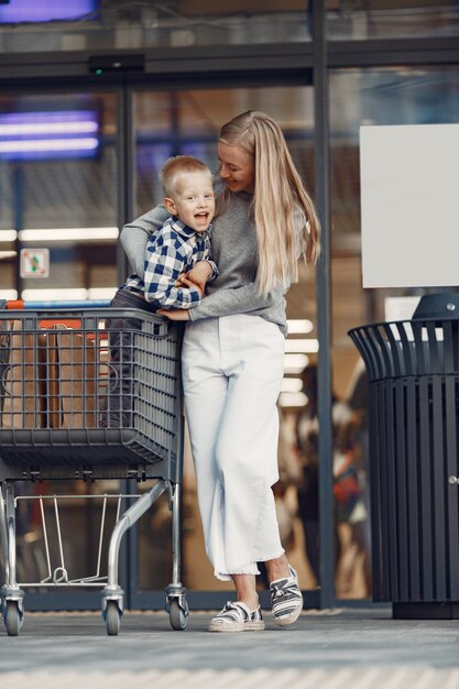 La madre conduce un tranvía. Familia en un parking cerca de un supermercado.