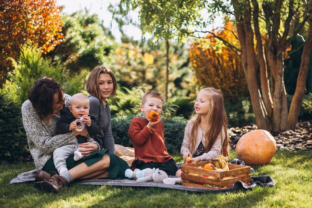 Madre con cuatro hijos haciendo un picnic en el patio trasero