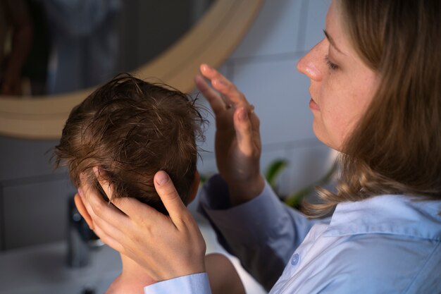 Madre cuidando a su hijo con piojos