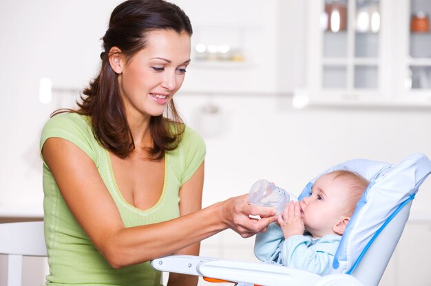 Madre dando agua al bebé