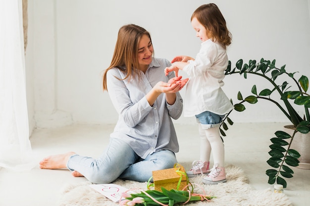 Madre dando pequeño regalo a hija