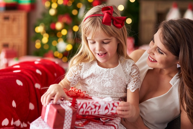 Madre dando a su hija un montón de regalos