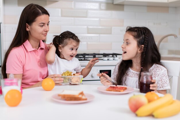 Madre desayunando con hijas