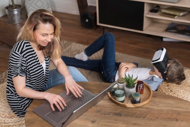 Foto gratuita madre disfruta trabajando desde casa