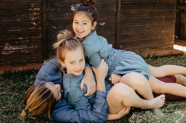 Madre divirtiéndose con hijas en la hierba