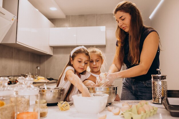 Madre con dos hijas en la cocina para hornear