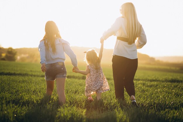 Madre con dos hijas en puesta de sol