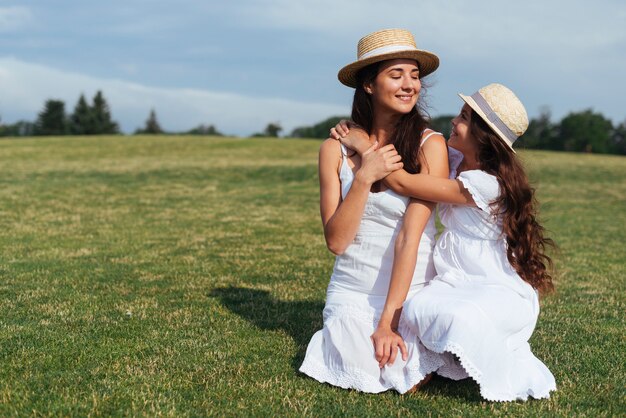 Madre e hija abrazando al aire libre