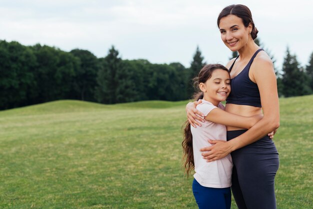 Madre e hija abrazando en la naturaleza