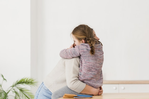 Foto gratuita madre e hija abrazando vista lateral