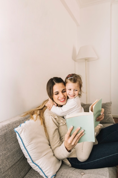 Madre e hija abrazándose y leyendo el libro