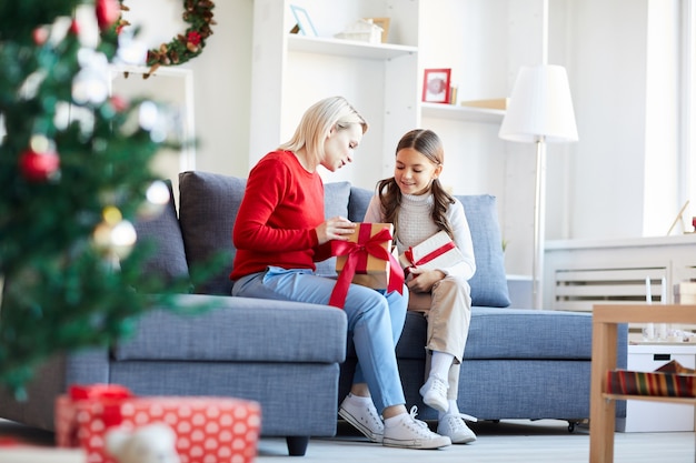 Madre e hija abriendo regalos de Navidad