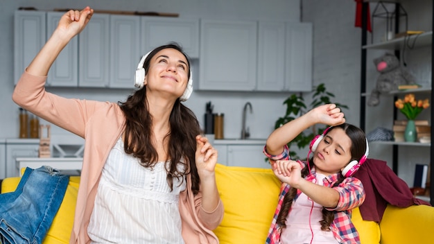 Madre e hija bailando y escuchando música