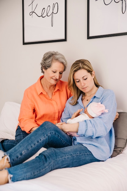 Madre e hija con bebé en cama