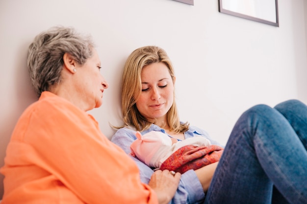 Madre e hija con bebé en casa