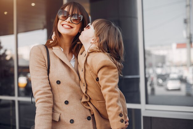 Madre e hija con bolsa de compras en una ciudad