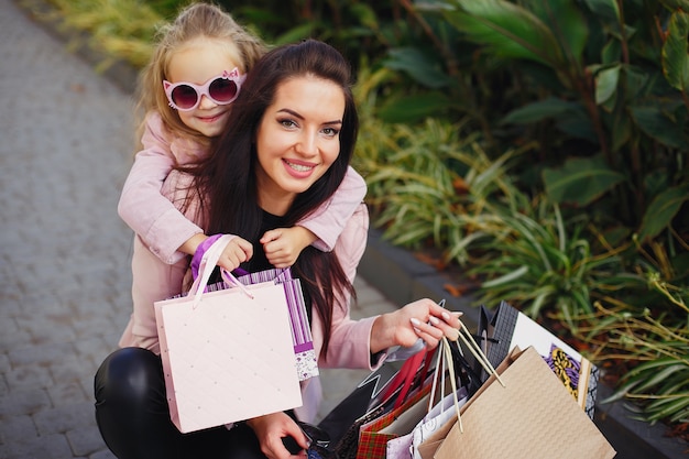 Foto gratuita madre e hija con bolsa de compras en una ciudad