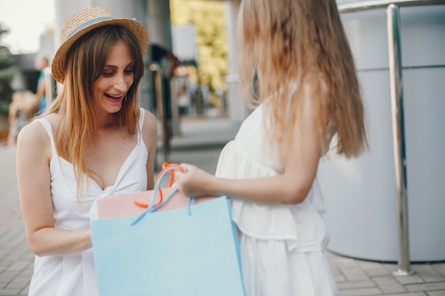 Madre e hija con bolsa de compras en una ciudad