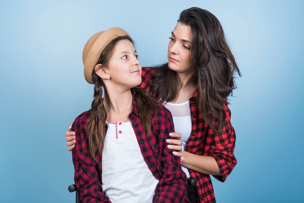 Madre e hija en camisas mirándose