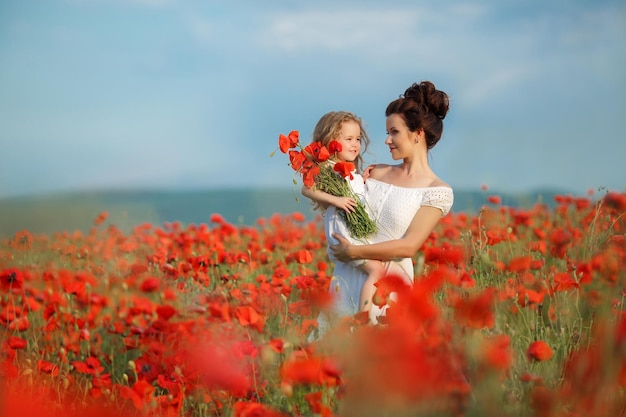 madre e hija en campo de amapolas