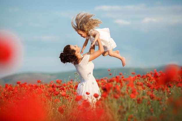 madre e hija en campo de amapolas