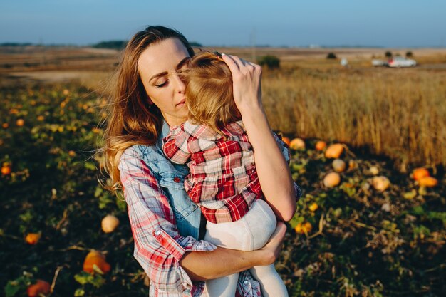 Madre e hija en un campo con calabazas