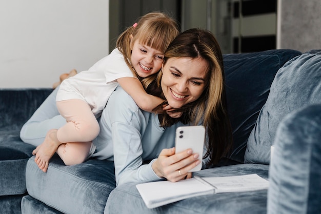 Madre e hija en casa tomando una foto propia