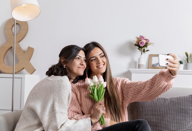 Madre e hija en casa tomando selfie