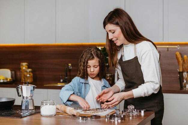 Foto gratuita madre e hija cocinando juntas en casa en la cocina