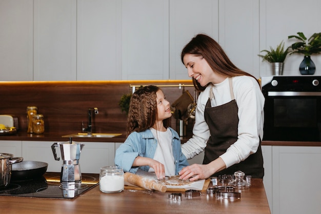 Madre e hija cocinando juntas en la cocina de casa