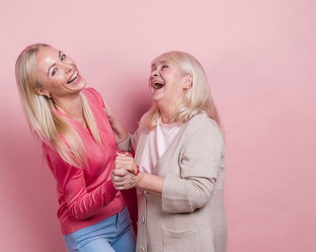 Madre e hija cogidos de la mano y jugando