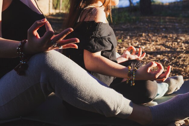 Madre e hija de la cosecha meditando en el parque