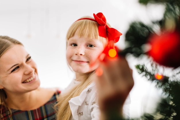 Madre e hija decorando árbol de navidad