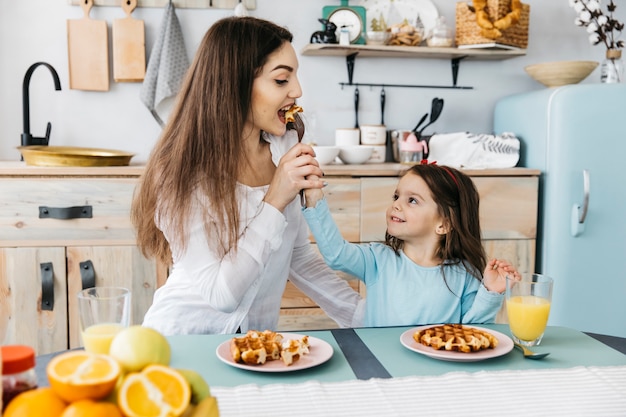 Foto gratuita madre e hija desayunando