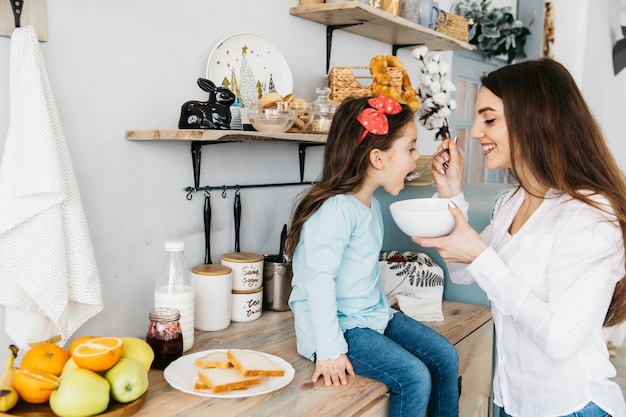 Foto gratuita madre e hija desayunando