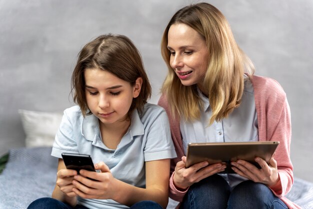 Madre e hija con dispositivos.