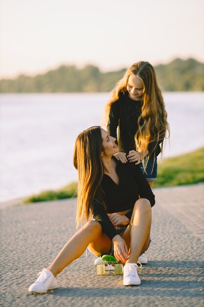 Madre e hija se divierten patinando en el parque