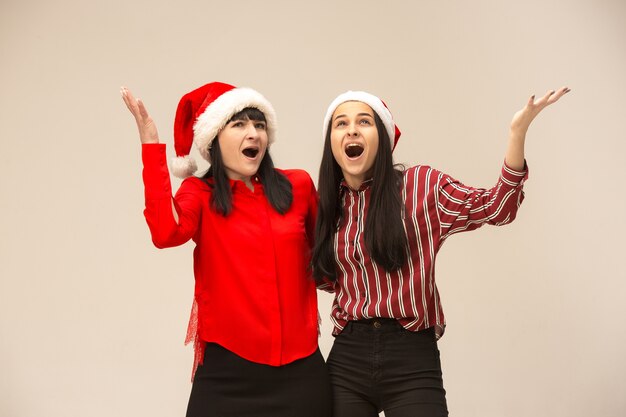 Madre e hija con gorro de Papá Noel. Expresión emocional.