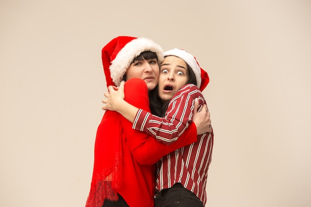 Madre e hija con gorro de Papá Noel. Expresión emocional.